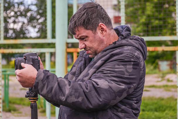 a man with a camera in warm clothes in cool weather - Foto, afbeelding