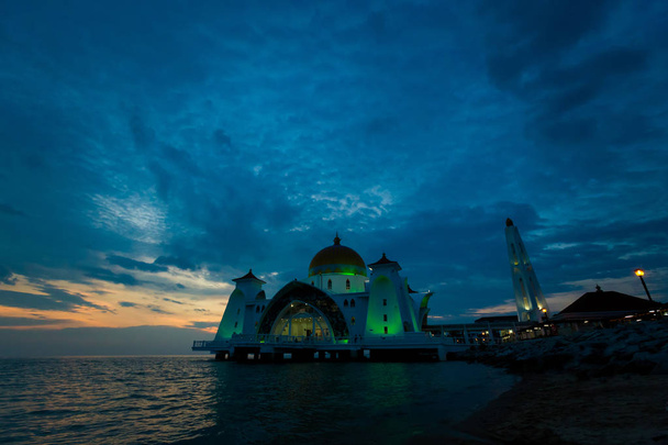 Hermosa arquitectura de la Mezquita del Estrecho de Melaka en la ciudad de Malaca en Malasia. Hermoso edificio sacro en el sudeste asiático durante la puesta del sol
. - Foto, Imagen