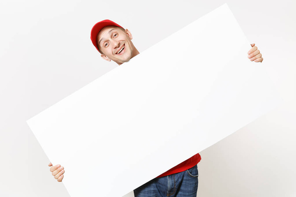 Dostawy młody człowiek w jednolity czerwony na białym tle. Mężczyzna Kurier w WPR, t-shirt, posiadający duży biały papier pusty billboard. Kopiować miejsca ogłoszenie. Miejsce dla obrazu tekstu. Powierzchnia reklamowa - Zdjęcie, obraz