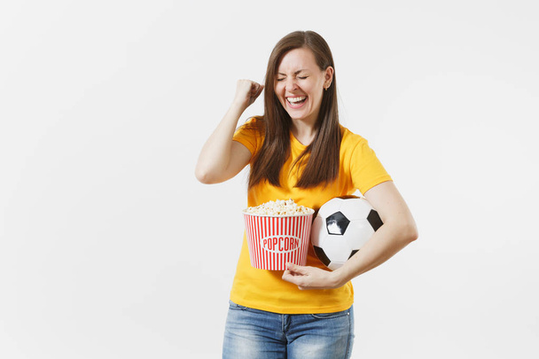 Uśmiechnięte młode kobiety, fan piłki nożnej lub gracz w mundurze żółty trzymając piłkę, wiadro popcornu na białym tle na białym tle. Sport, grać w piłkę nożną, dopingować, fanów ludzi lifestyle concept - Zdjęcie, obraz