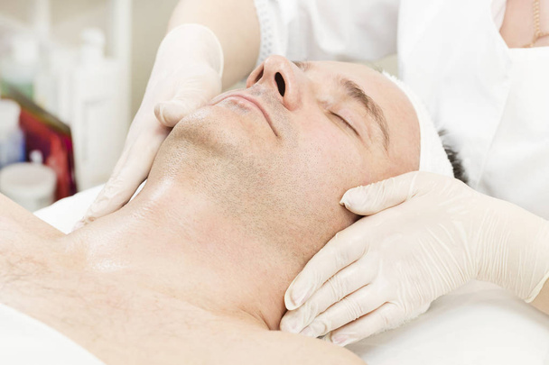 Man in the mask cosmetic procedure in spa salon - Foto, afbeelding
