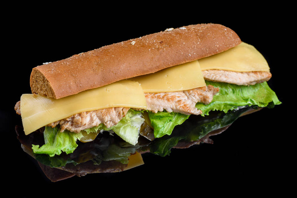 Sandwich met filet gegrild kip, verse groenten, kaas en greens, geïsoleerd op zwarte achtergrond. - Foto, afbeelding