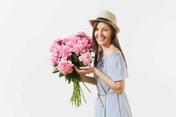 junge zarte Frau in blauem Kleid, Hut mit Strauß schöner rosa Pfingstrosen Blumen isoliert auf weißem Hintergrund. Valentinstag, internationales Frauentagskonzept. Werbefläche - Foto, Bild