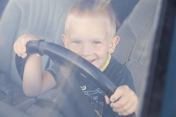 Zdjęcie z małego chłopca jest jazda samochodem - Zdjęcie, obraz