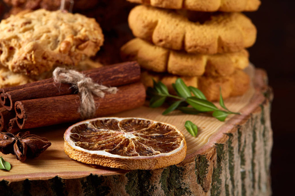 Conceptual composition with assortment of cookies and cinnamon on a wooden barrel, selective focus, close-up - Zdjęcie, obraz