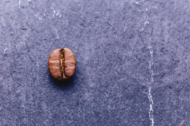 un grano de café sobre fondo de piedra negra
 - Foto, imagen
