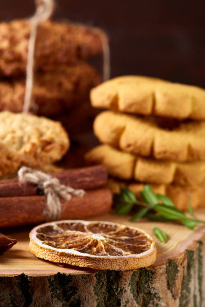 Conceptual composition with assortment of cookies and cinnamon on a wooden barrel, selective focus, close-up - Zdjęcie, obraz