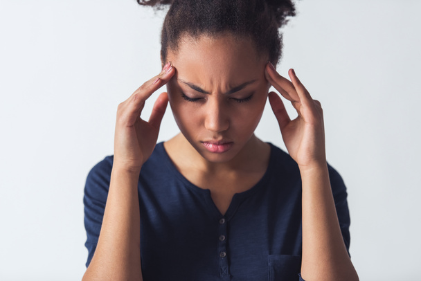 schöne afroamerikanische Mädchen in lässiger Kleidung berührt ihre Schläfen mit Kopfschmerzen, isoliert auf weiß - Foto, Bild
