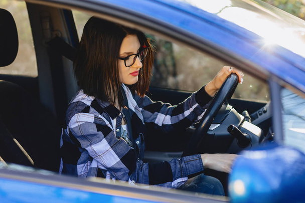 Девушка сидит за рулем автомобиля в свете заката
 - Фото, изображение