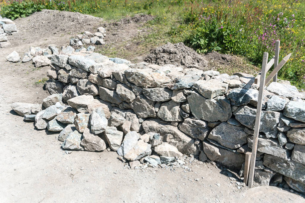traditional rock wall construction site with wooden frame in the Swiss Alps - Photo, Image