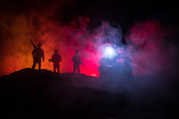 Concetto di guerra. Silhouette militari scena di combattimento su sfondo cielo nebbia di guerra, silhouette di combattimento sotto cielo nuvoloso Di notte. Scena di battaglia. Jeep dell'esercito con soldati. jeep dell'esercito
 - Foto, immagini