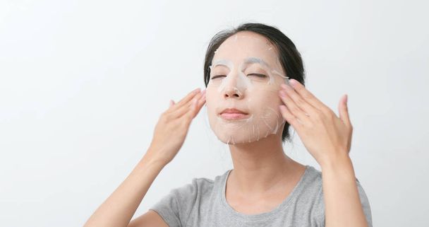 Asian Woman zastosowanie papieru maski na twarz - Zdjęcie, obraz