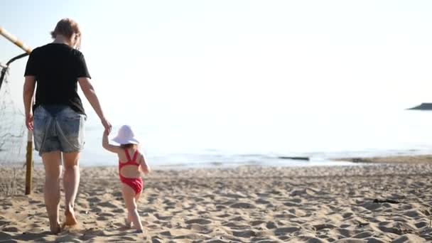Мати і дочка гуляють і грають на пляжі
 - Кадри, відео