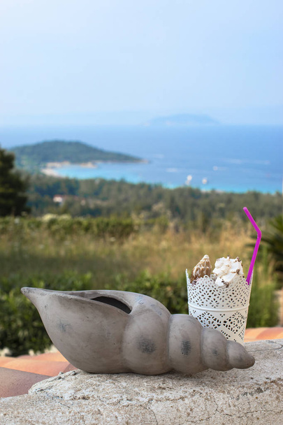 Summer coctail fresh concept idea. Sea shells coctail on the summer beach landscape background. - Photo, Image