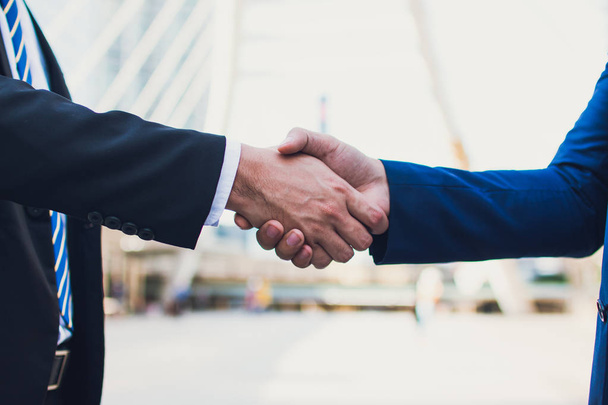 Two confident businessman shaking hands. Successful business partners. Negotiating business. The business man happy with work and enjoy with workmate. Finishing up a meeting. - Photo, Image