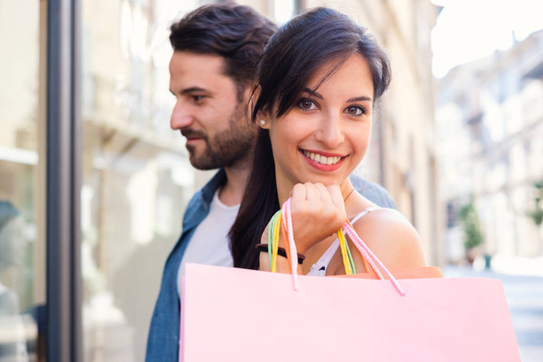 Giovane coppia felice con shopping bag in città durante le vendite stagionali
 - Foto, immagini