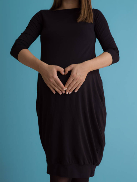 Mavi arka plan üzerinde izole oryantal ellerde ile mutlu hamile kadın portresi - Fotoğraf, Görsel