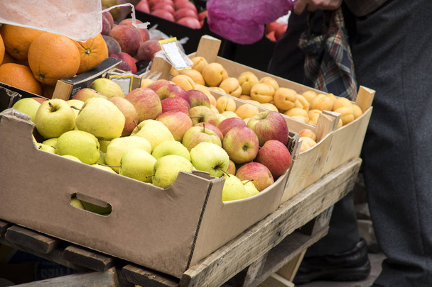 Апельсини, яблука та персики в коробці для продажу, літо
 - Фото, зображення