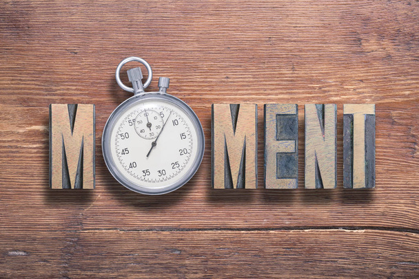 moment word combined on vintage varnished wooden surface with stopwatch inside - Photo, Image