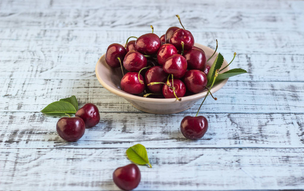 Fresh cherry on plate on wooden blue background. fresh ripe cherries. sweet cherries. - Fotografie, Obrázek