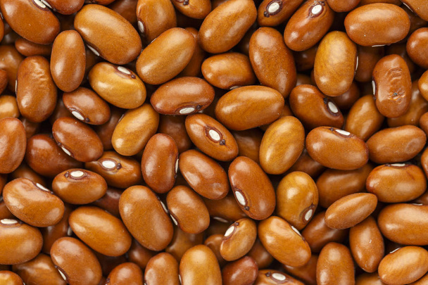 a lot of raw beans close-up scattered as a background, space for tex - Fotoğraf, Görsel