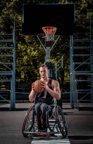 Πορτρέτο του έναν παίκτη μπάσκετ με αναπηρία σε αναπηρικό αμαξίδιο επιτόπου ανοιχτό τυχερών παιχνιδιών. - Φωτογραφία, εικόνα