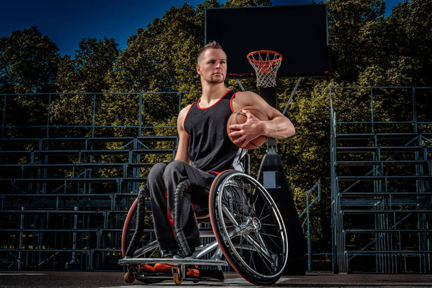 Portrait of a disabled basketball player in a wheelchair on open gaming ground. - Photo, Image