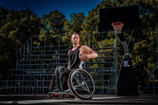 Porträt eines behinderten Basketballspielers im Rollstuhl auf offenem Spielfeld. - Foto, Bild