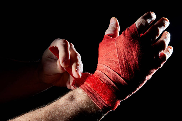 A boxers red bandage on his hand isolated on dark blurred background, close-up. - Φωτογραφία, εικόνα