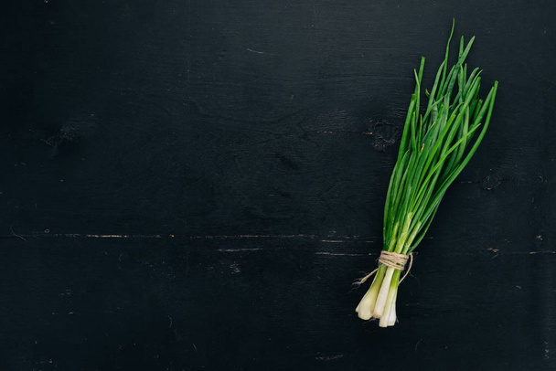 Fresh green onion. On a wooden background. Top view. Copy space. - Фото, зображення