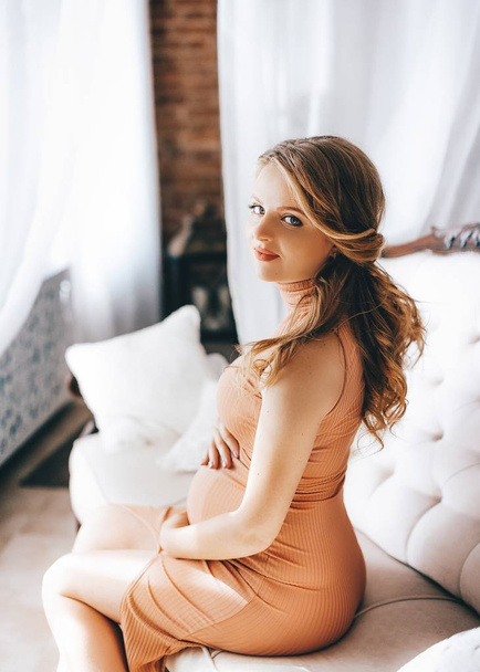 Portrait of a beautiful pregnant woman in dress in studio  - Foto, Imagem