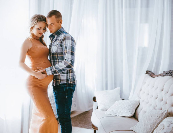 Beautiful young couple expecting baby posing in Studio  - Photo, Image