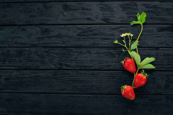 Fresh strawberries. On a black wooden background. Top view. Copy space. - Foto, Bild