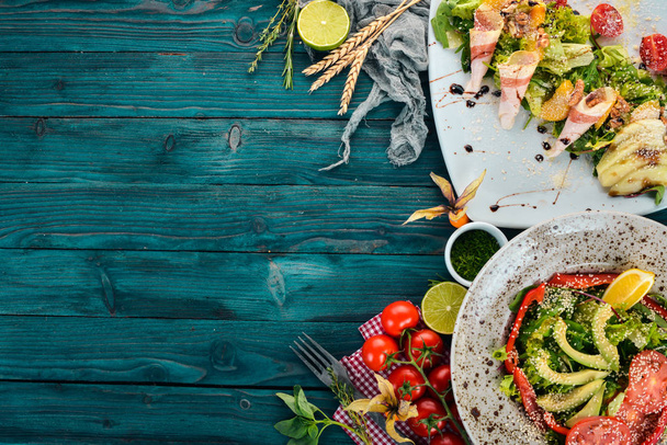 食品。アボカドと野菜のおいしいサラダのセット。木製の背景。平面図です。コピー スペース. - 写真・画像