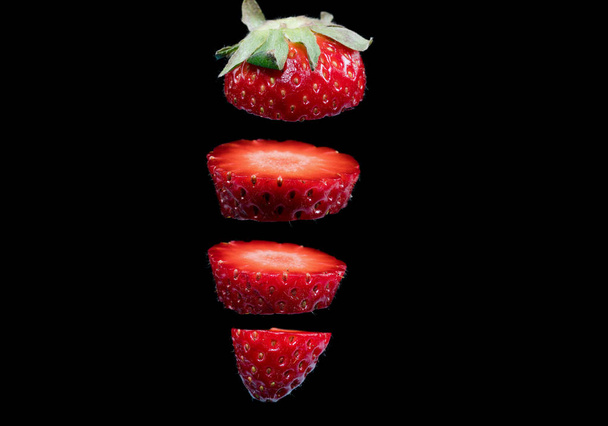 sliced strawberry and black background - Photo, Image