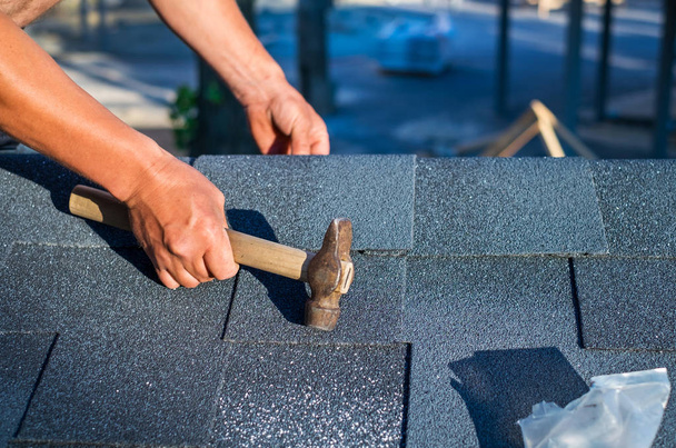 屋根葺き職人のハンマーと釘コーナー アスファルト屋根の鉄片をインストール. - 写真・画像