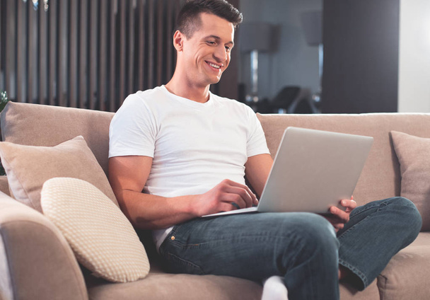 Relaxed man using modern computer in living room  - Zdjęcie, obraz