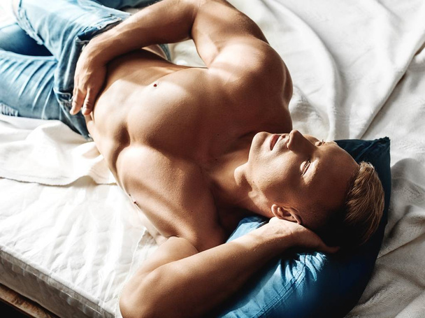 Portret van sterke gezonde knappe atletische Man die zich voordeed in bed - Foto, afbeelding