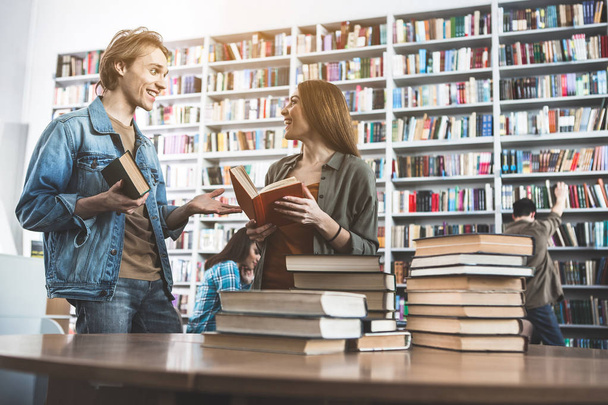 Glad male and woman talking in library - Foto, Bild