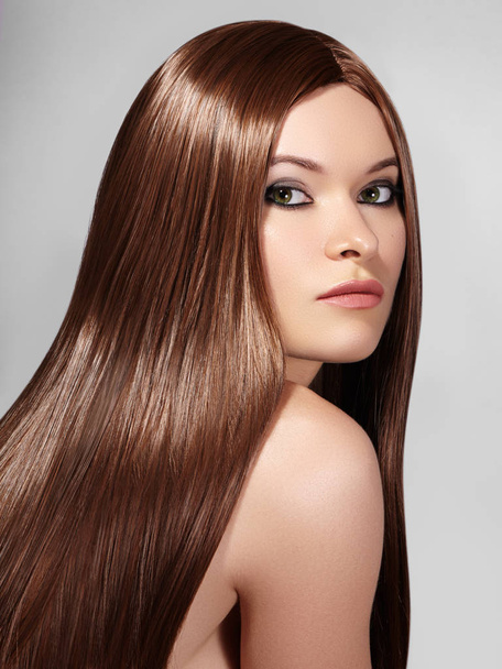 Gyönyörű yong hosszú egyenes barna hajú nő. Szexi divat modell sima fényes frizura. Szépség make-up, keratin kezelés - Fotó, kép
