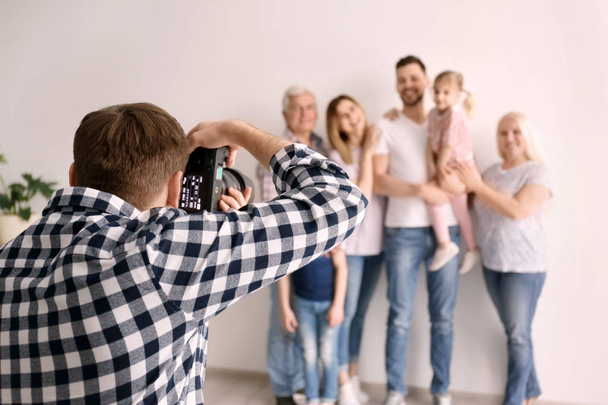 Professional photographer taking photo of family in studio - Φωτογραφία, εικόνα