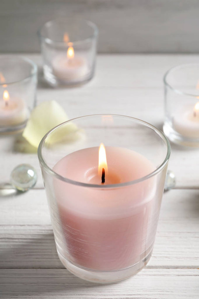Beautiful burning wax candle in glass on table - Fotoğraf, Görsel