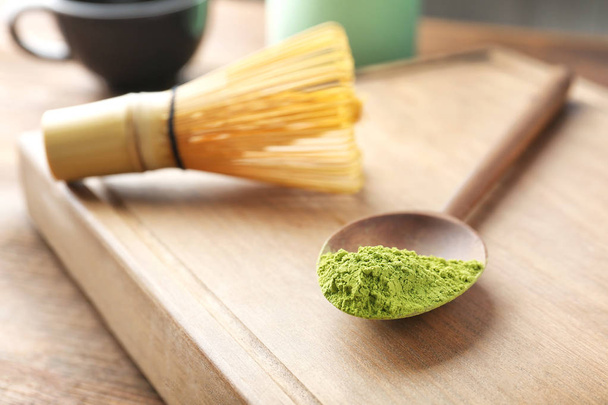 Spoon with powdered matcha tea on wooden board, closeup - Photo, image
