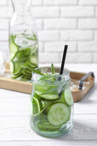 Natural lemonade with cucumber and rosemary in jar on table - Foto, Imagem