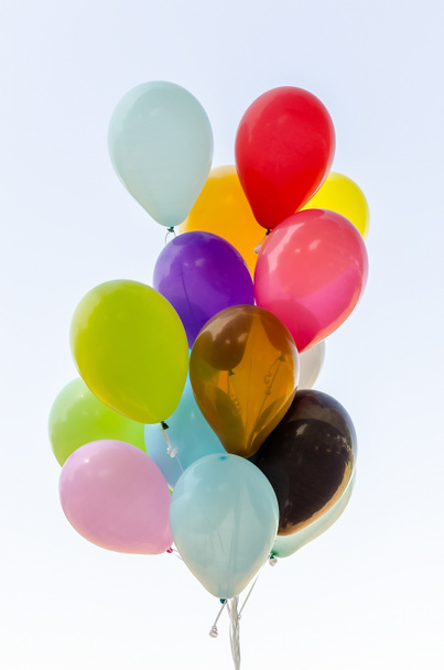 Colorful bunch of helium balloons isolated on background - 写真・画像