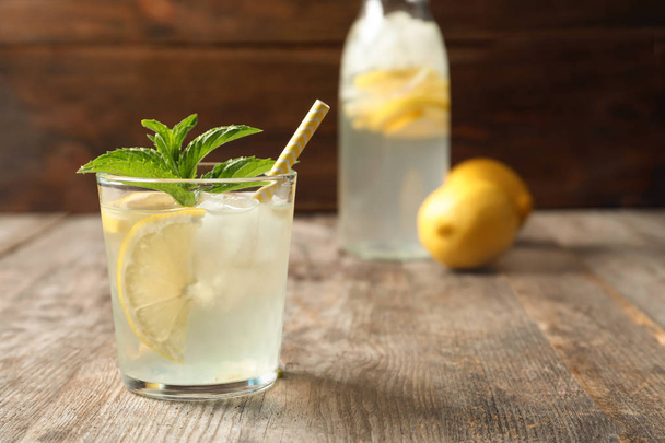 Natural lemonade with mint in glass on wooden table - Fotoğraf, Görsel