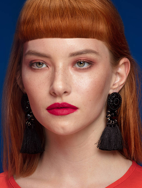 Elegant redhead woman wearing black fashionable earrings. Girl with glamour makeup. - Photo, Image