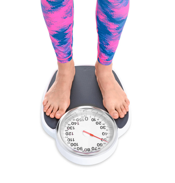 Young woman measuring her weight using scales on white background. Weight loss motivation - Foto, immagini