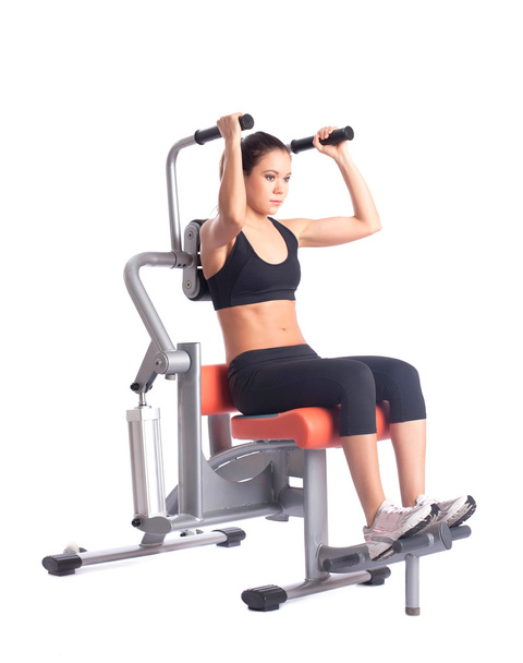 Young woman on orange hydraulic exerciser - Foto, Imagen