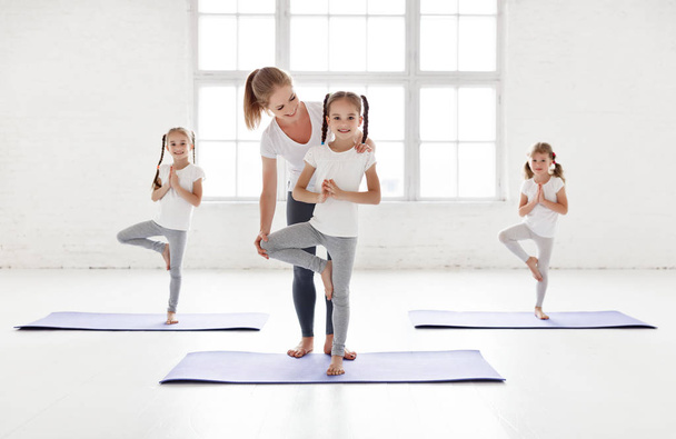 les enfants pratiquant sont engagés dans la gymnastique et le yoga avec des maux de tête
 - Photo, image